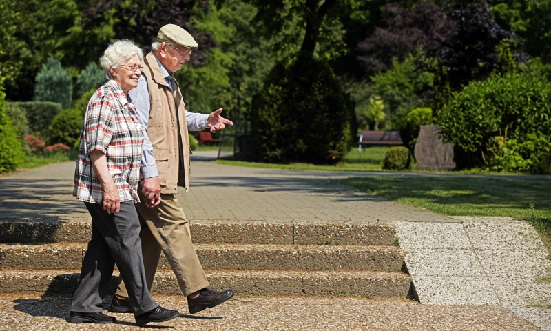 Older couple walking in a park.