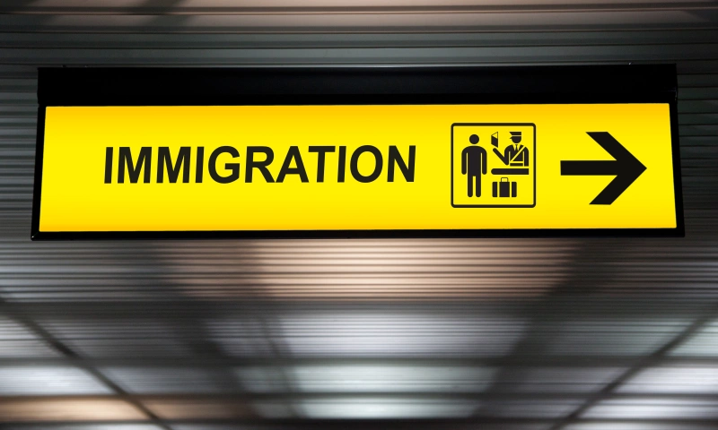 A yellow sign in an airport with the word 'immigration' on it.