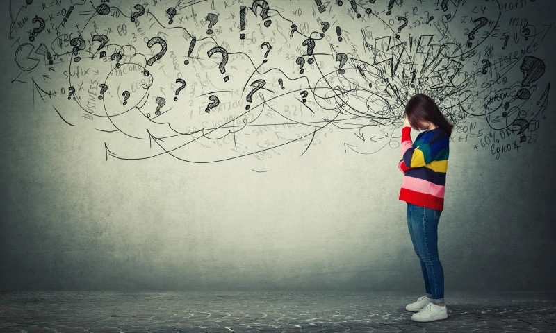 A young person on the right hand-side of the image, with drawn words and scribbles representing stress and anxiety.