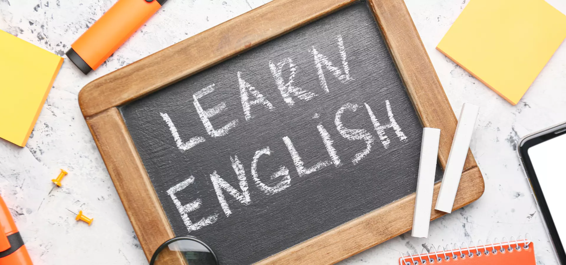 A small blackboard with the words 'Learn English' written in chalk. 