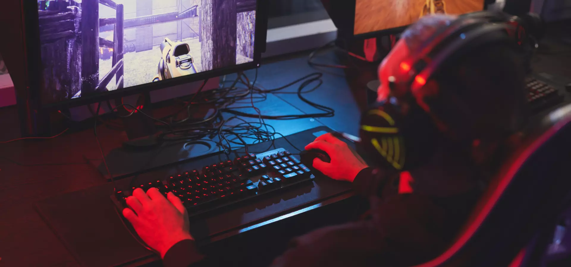 Teenager in a dark room playing video games.