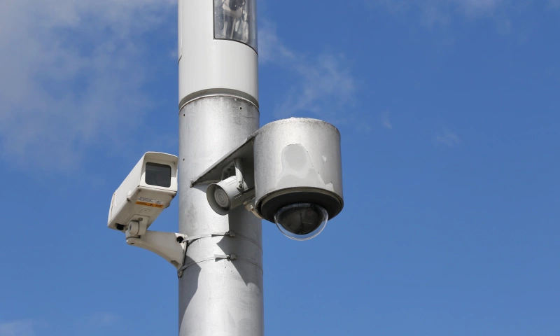 A cctv camera with blue sky in the background.