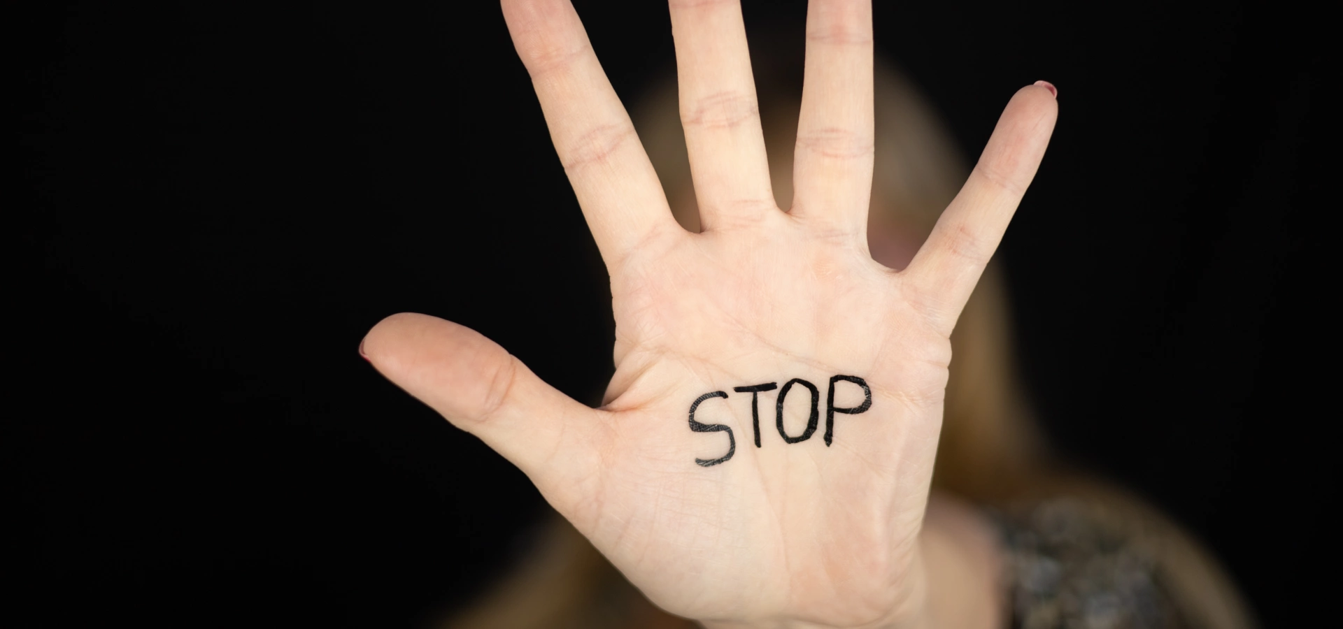 Hand of a woman with the word 'Stop' written on it.