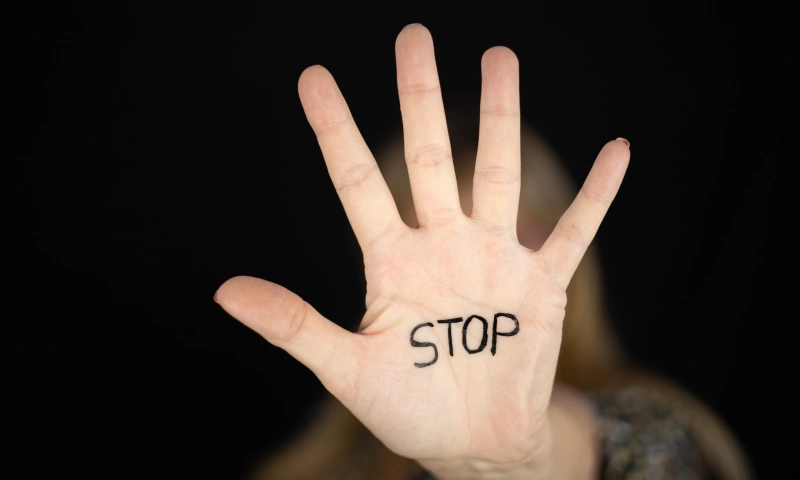 Hand of a woman with the word 'Stop' written on it.