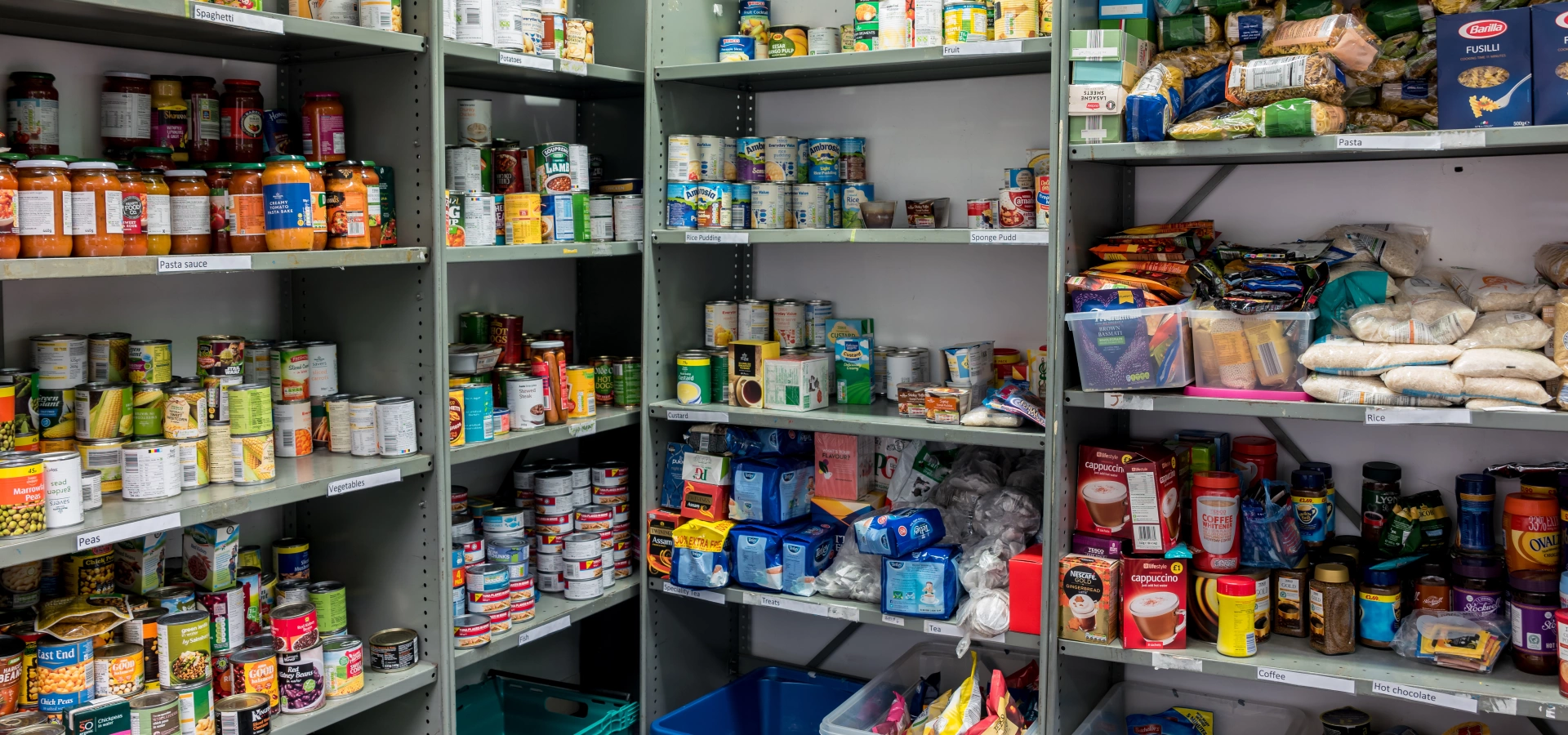 Shelves filled with tins and long lasting food in a food bank.