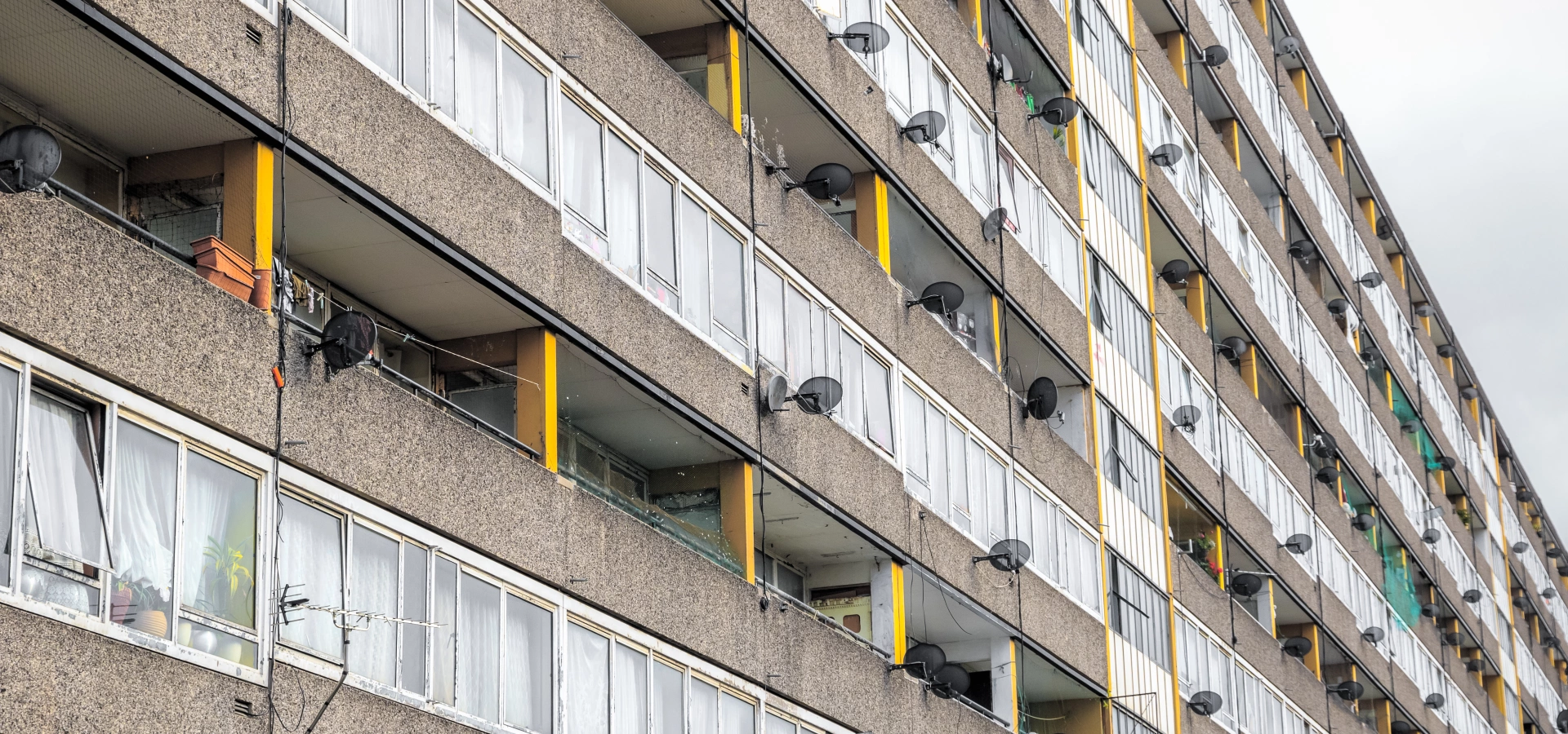 Tower block balconies with satellite dishes.