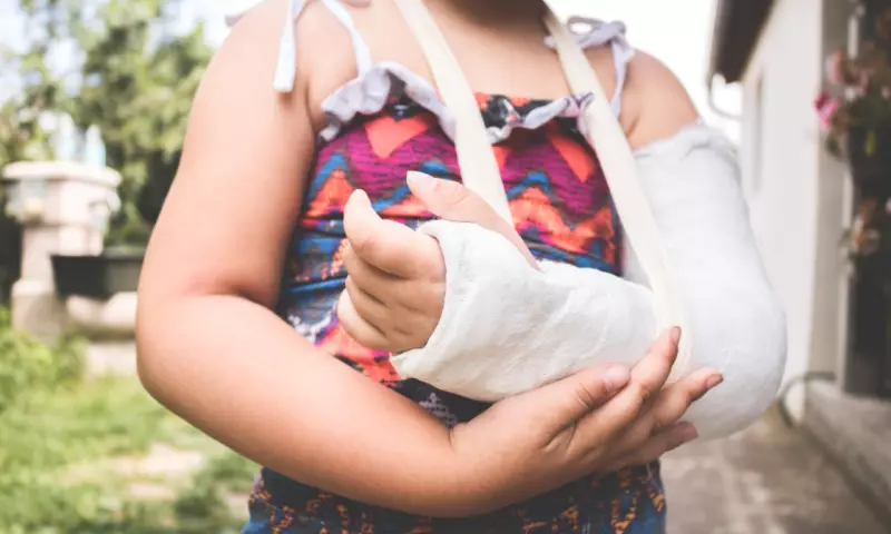 Young girl with a broken arm in a cast.