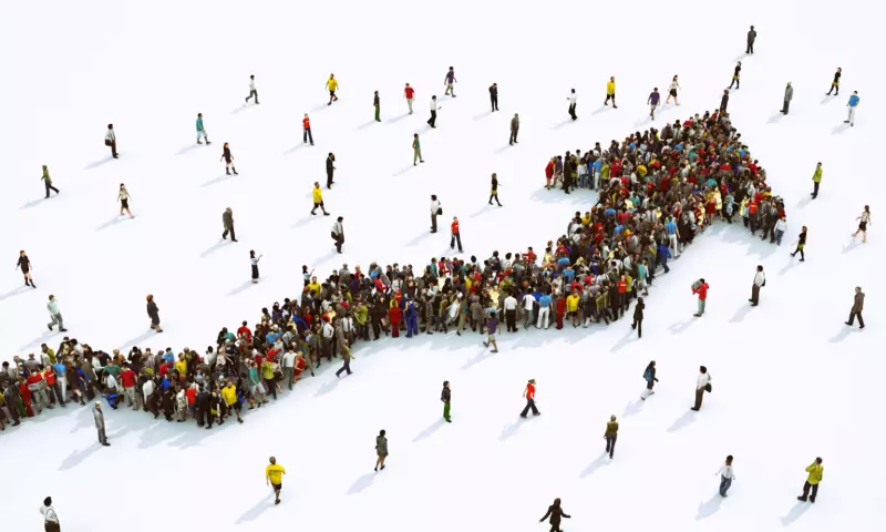 Rising arrow made of people, viewed from above.