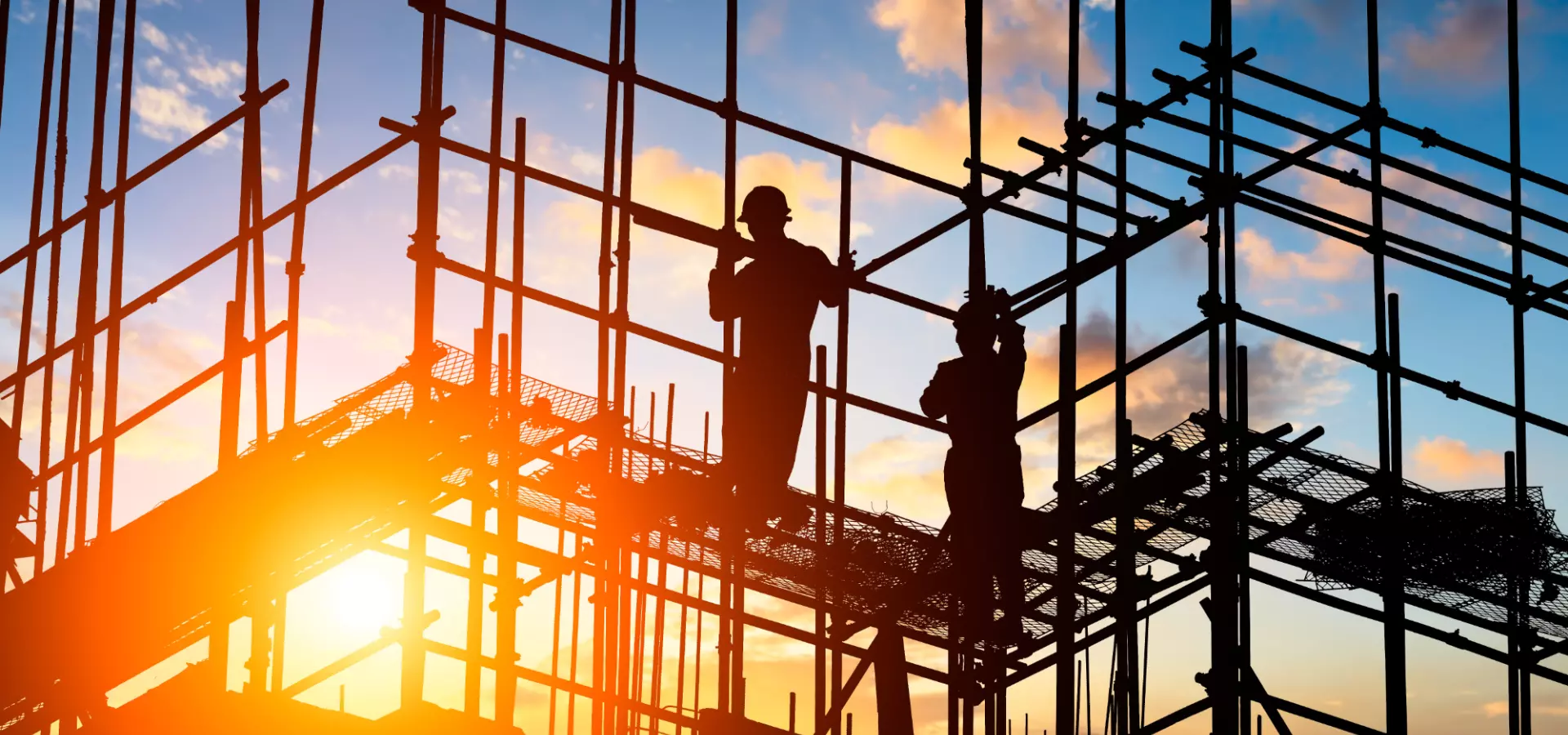 Two construction workers on scaffolding.