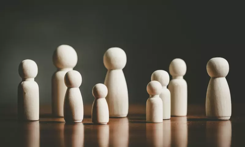 Wooden peg people of different sizes, representing different ages.