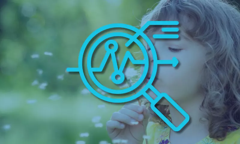 A young girl blowing on dandelion seeds, with a magnifying glass icon on top signifying 'overview'.