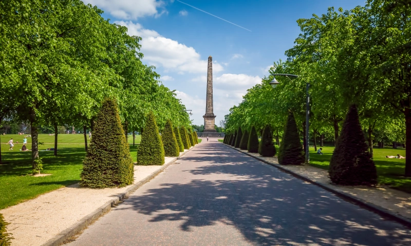 View of the obelisk monument in Glasgow green, with trees and greenery around.